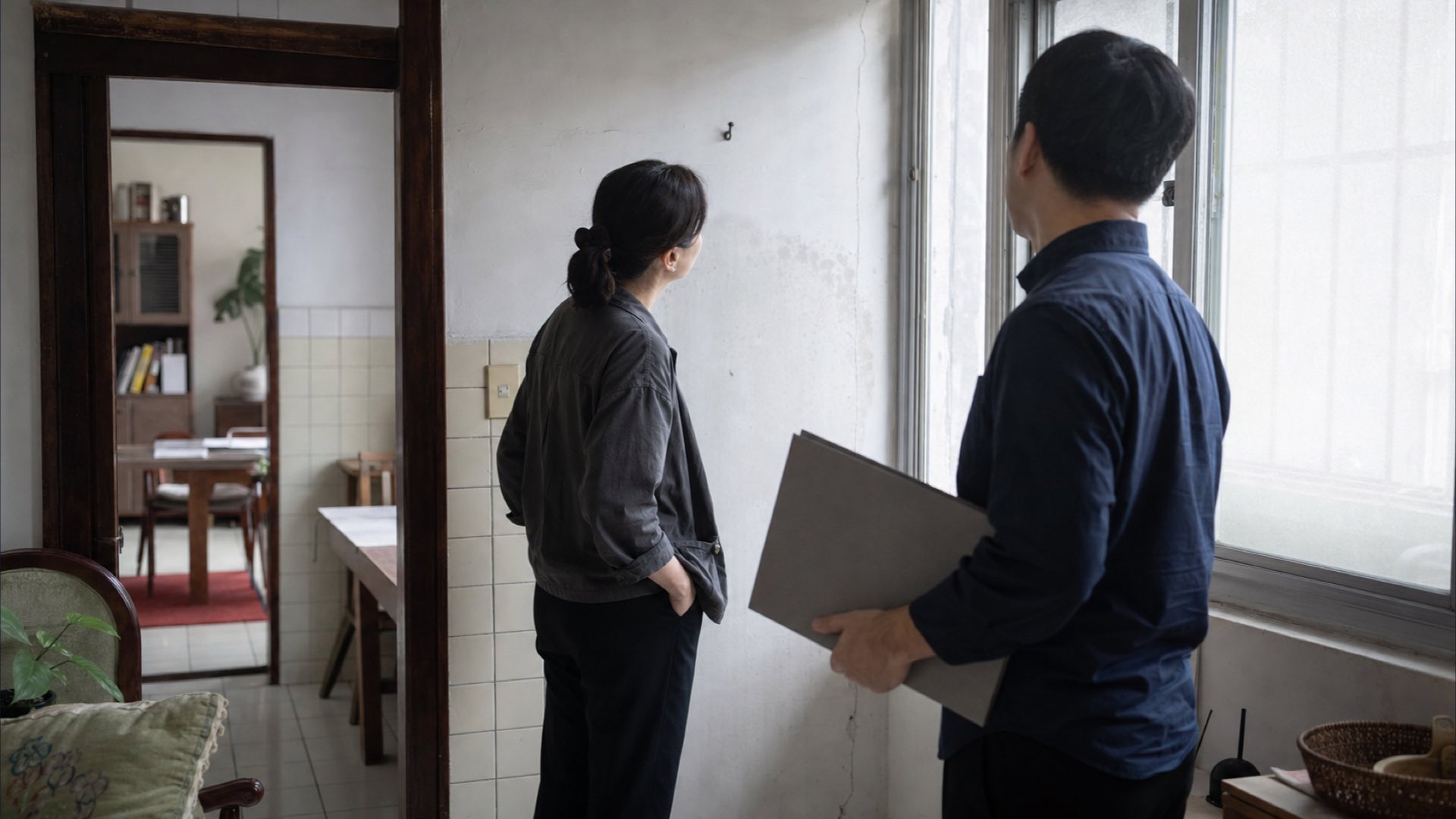 專業人員與屋主在老屋現場側身交談
